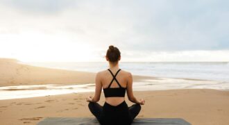 Morning meditation. Unrecognizable calm woman in activewear practicing yoga outdoors, sitting on