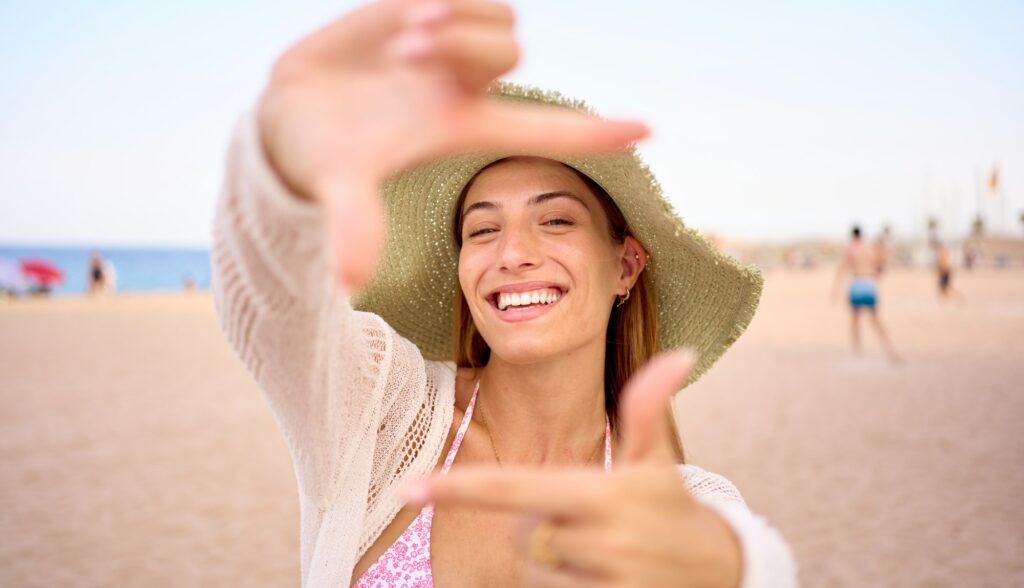 Portrait cheerful of attractive Caucasian woman with hat posing for photo doing hand frame